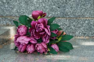 Bouquet of purple flowers on marble tomb